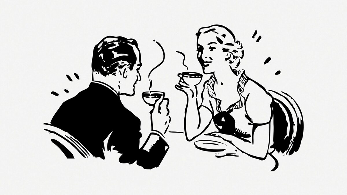 Two people talking face to face over coffee
