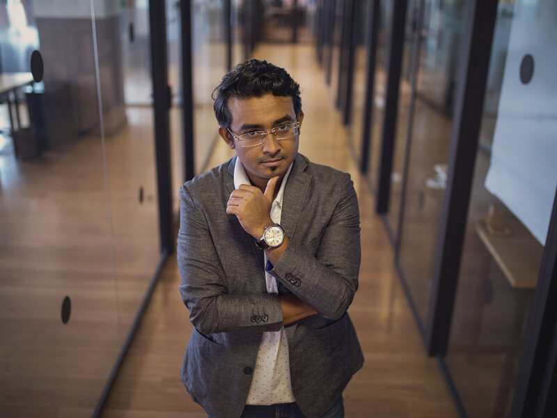 A representative in a blazer standing in a bright office corridor