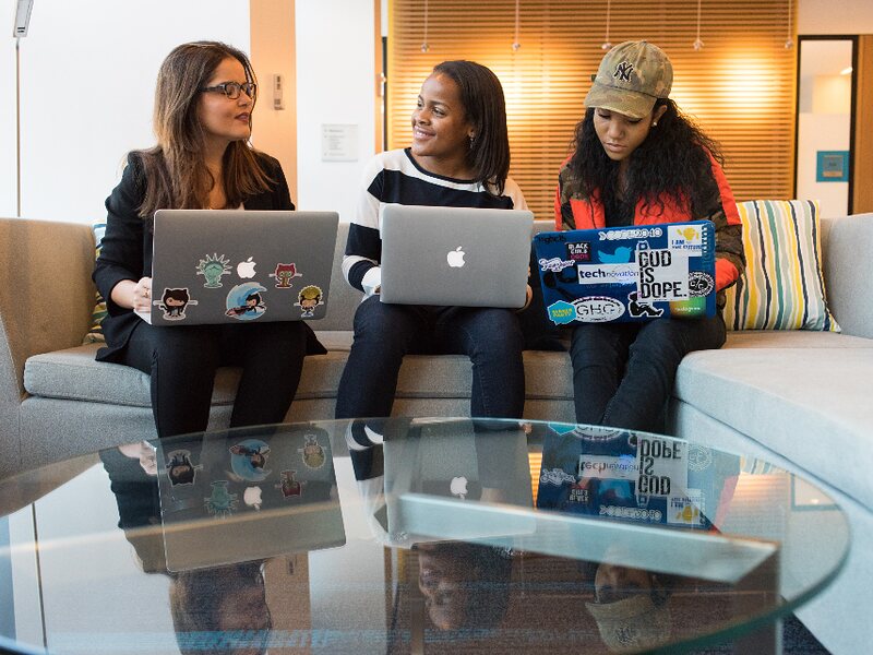 Three colleagues working through a session together over laptops