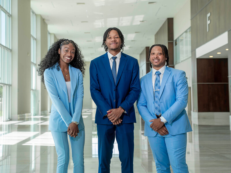 Three members of the EBM Marketing team standing in a building lobby