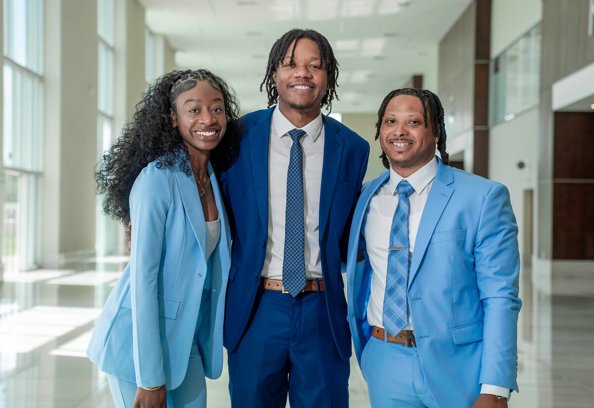 Three members of the EBM Marketing team standing together in a bright office lobby
