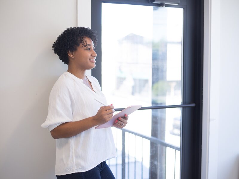 A field leader standing with a clipboard, working through the day&rsquo;s notes